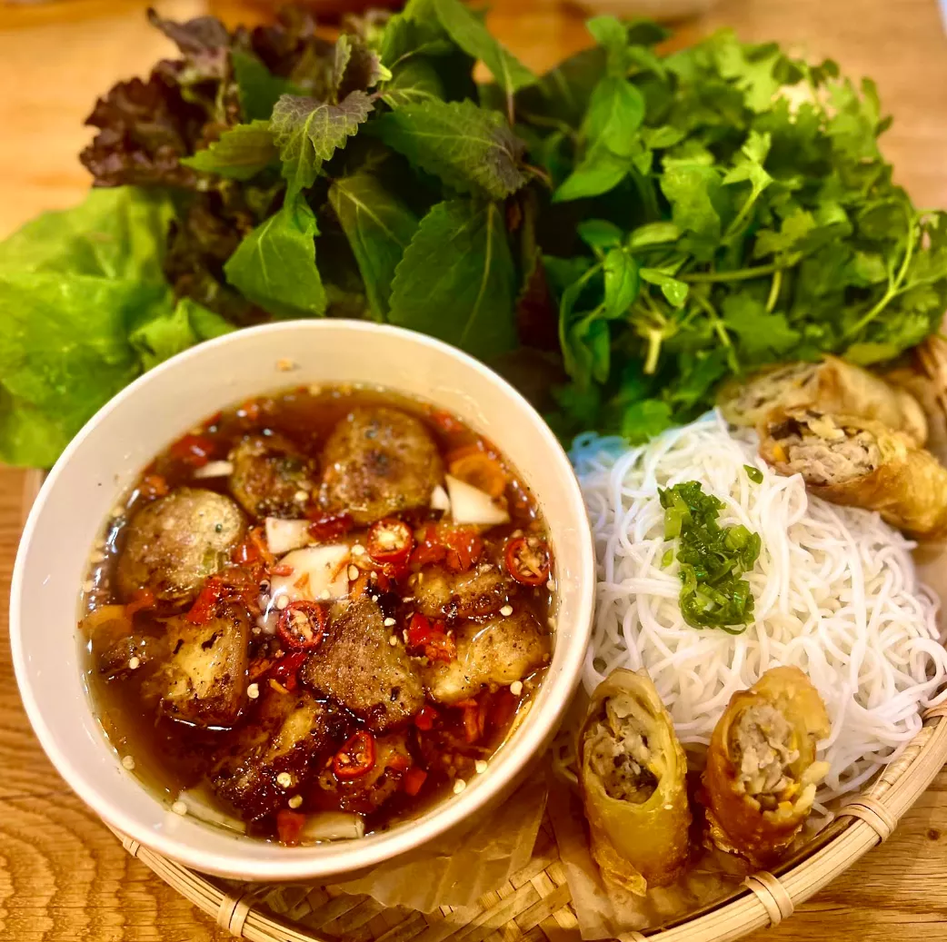 Vietnamese noodles with spring rolls and herbs